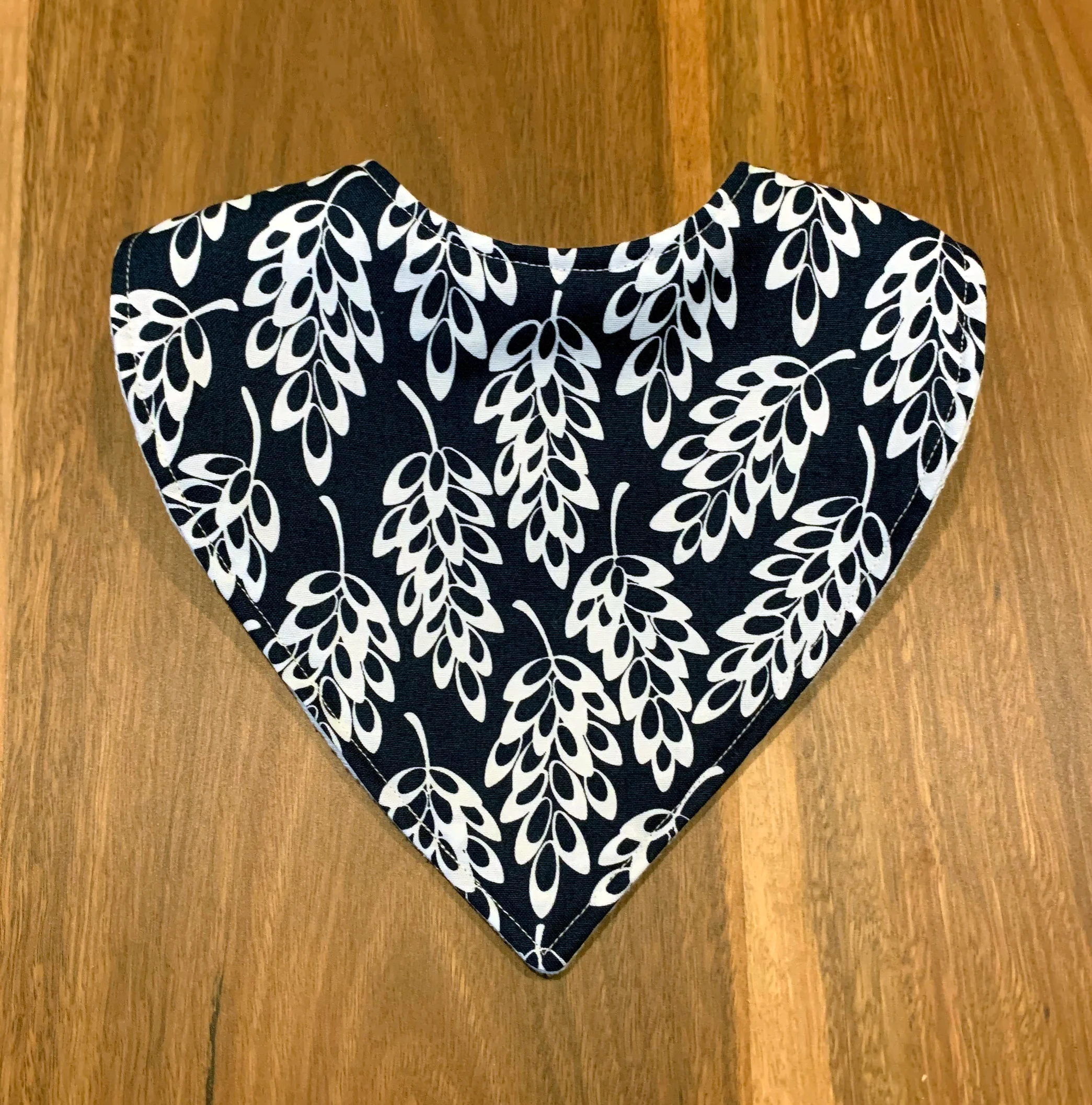 Dribble bib with white leaves on dark blue background