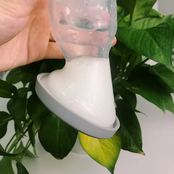 Haakaa silicone breast pump with cap and milk upside down