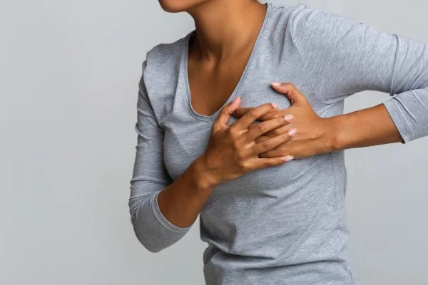 Woman clutching painful breast